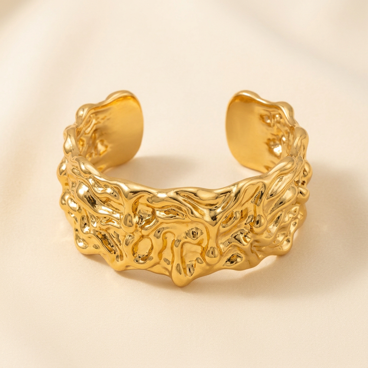 Molten gold statement cuff bracelet on a cream background