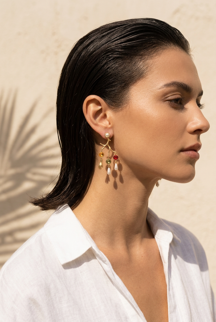 Gold coral branch charm earrings worn with a white linen shirt