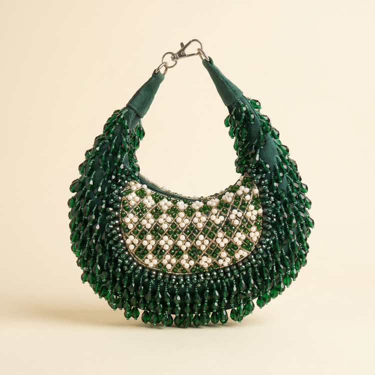 Emerald crystal crescent bag on a cream studio background