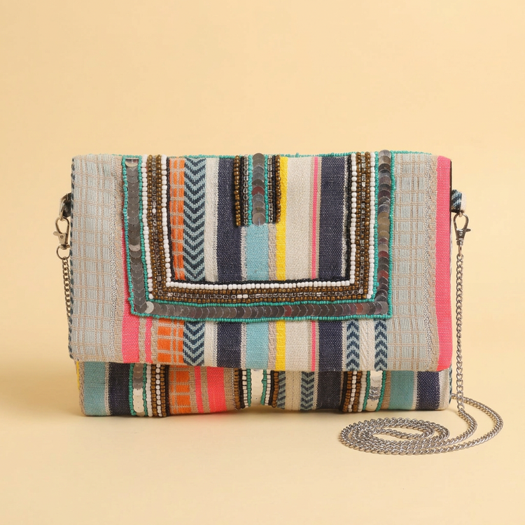 Prism striped clutch on a warm cream studio background