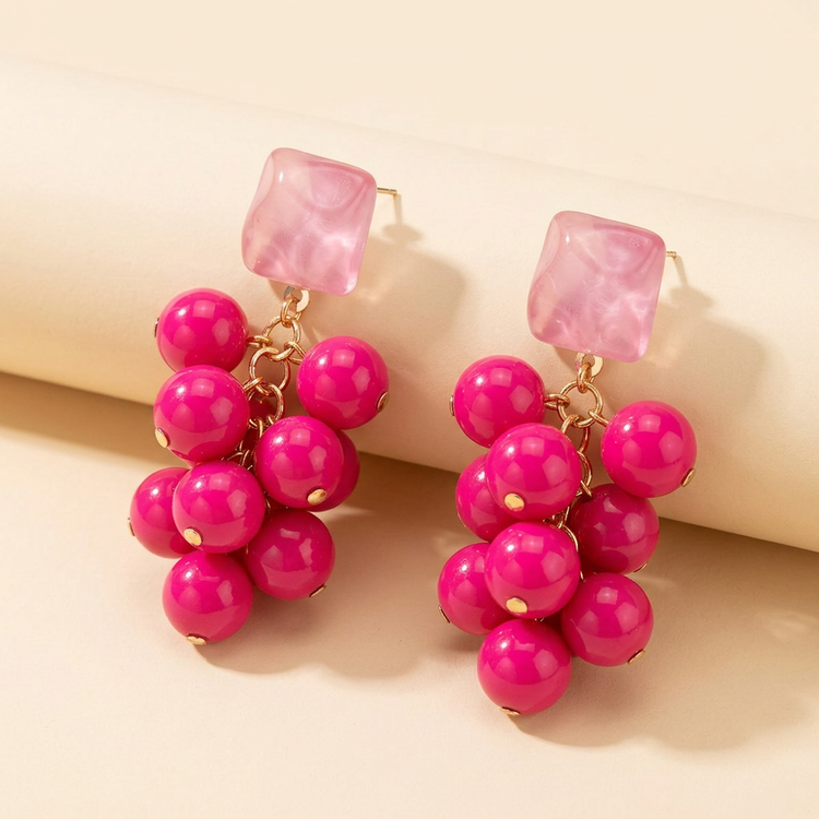 Pink berry cluster drop earrings with translucent pink square studs on cream