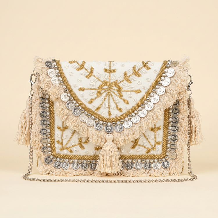 Ivory and gold coin fringe boho clutch on a cream studio background