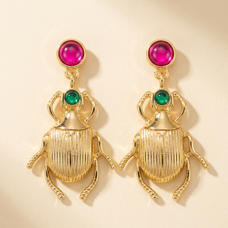 Pink and green gold beetle drop earrings studio image on cream