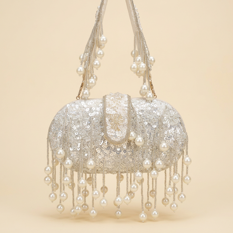 Pearl cascade sequin clutch on a cream studio background