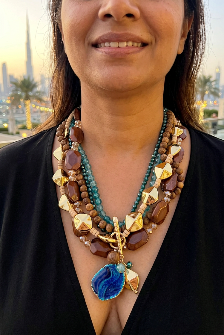 Teal and brown multistrand blue pendant necklace worn with black