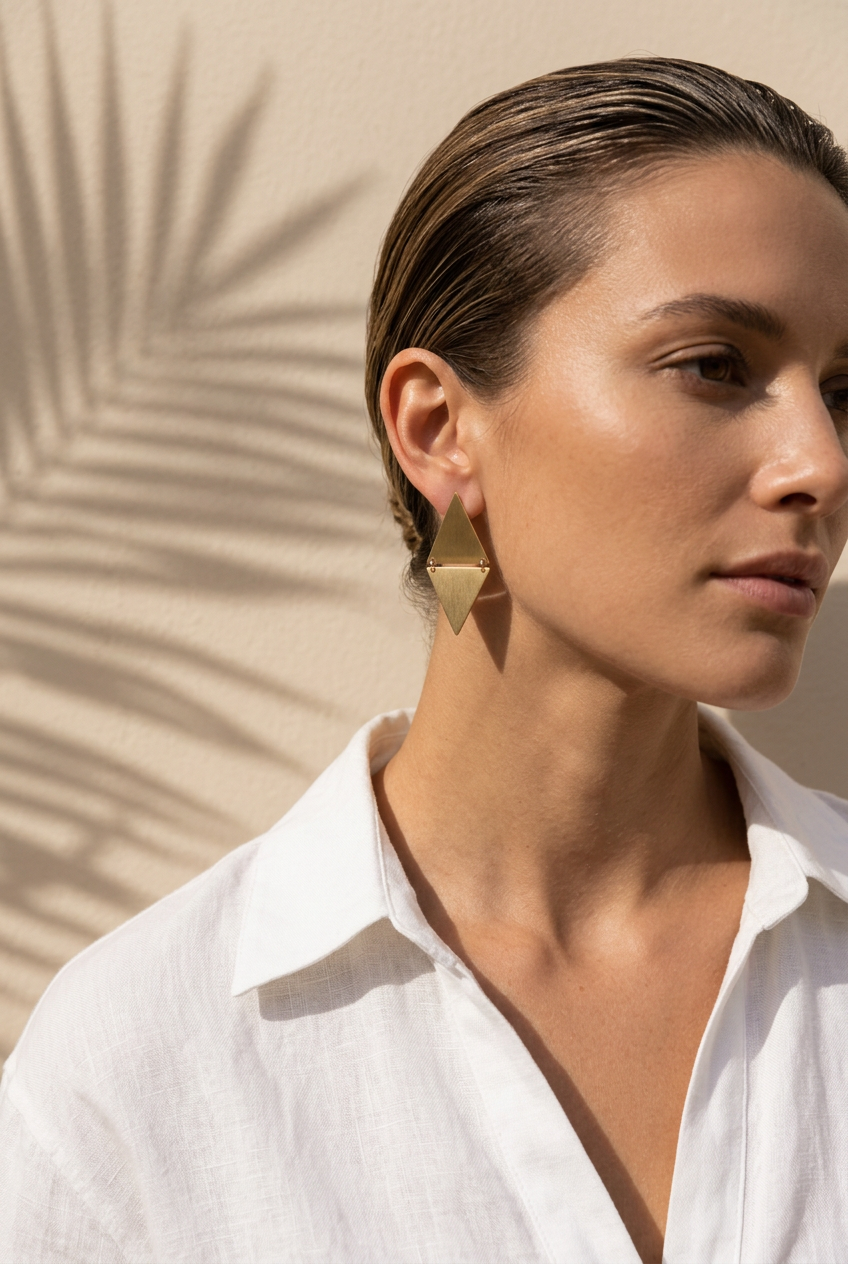 Brushed gold diamond earrings worn with a white linen shirt