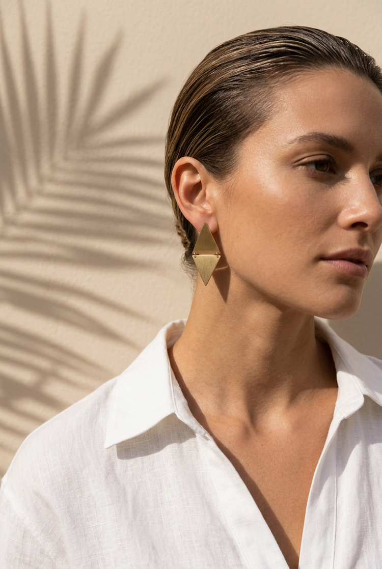 Brushed gold diamond earrings worn with a white linen shirt