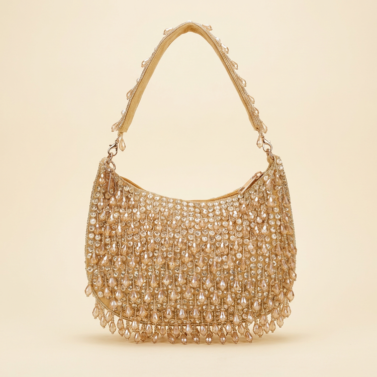 Champagne crystal fringe shoulder bag on a cream studio background