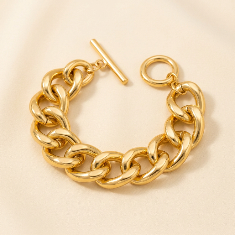 Chunky gold chain toggle bracelet on a cream background