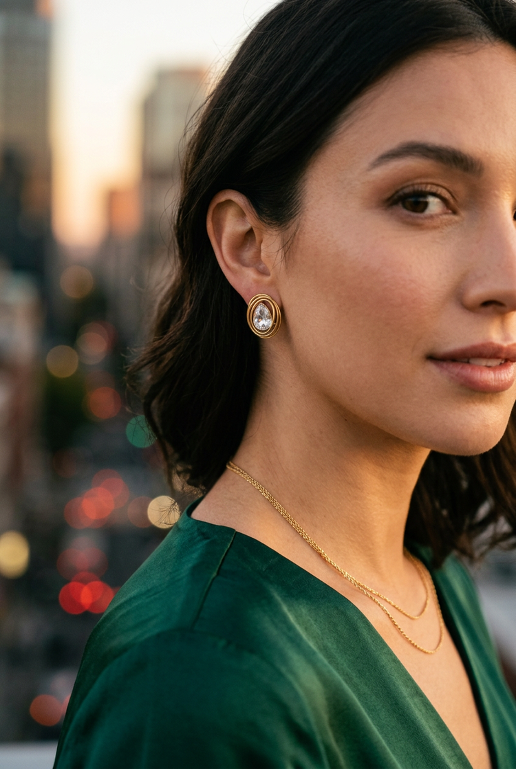 Crystal swirl gold studs worn on an evening rooftop