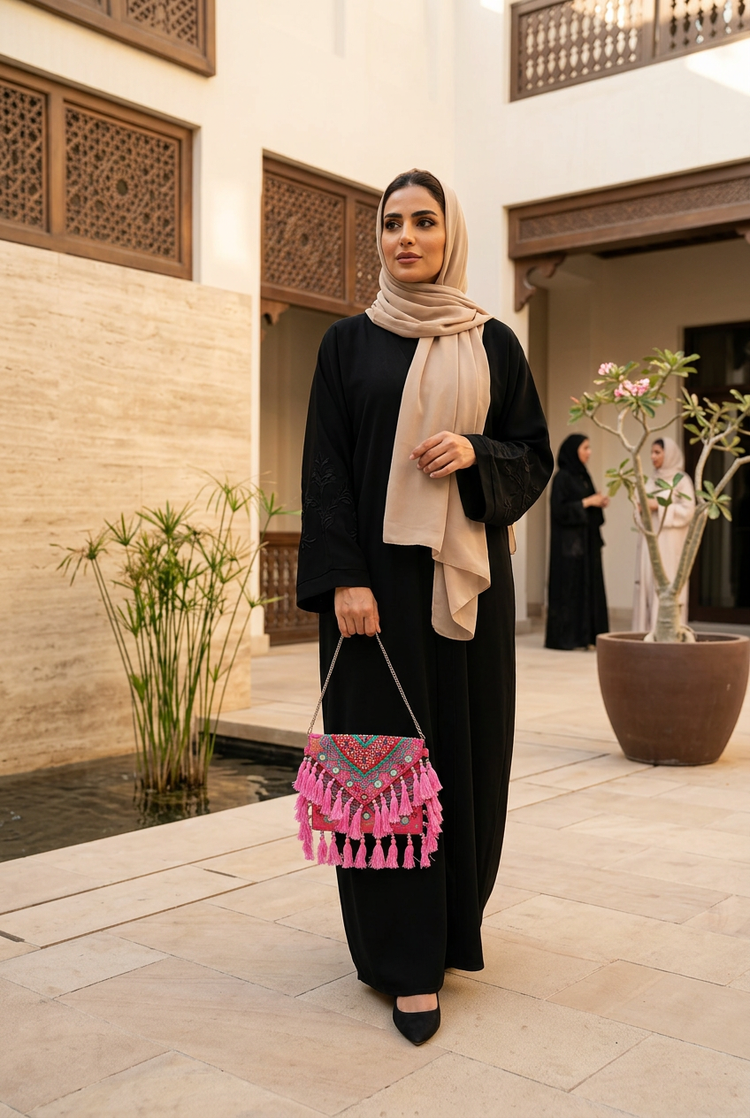 Rani pink bag styled with a black abaya and beige shayla