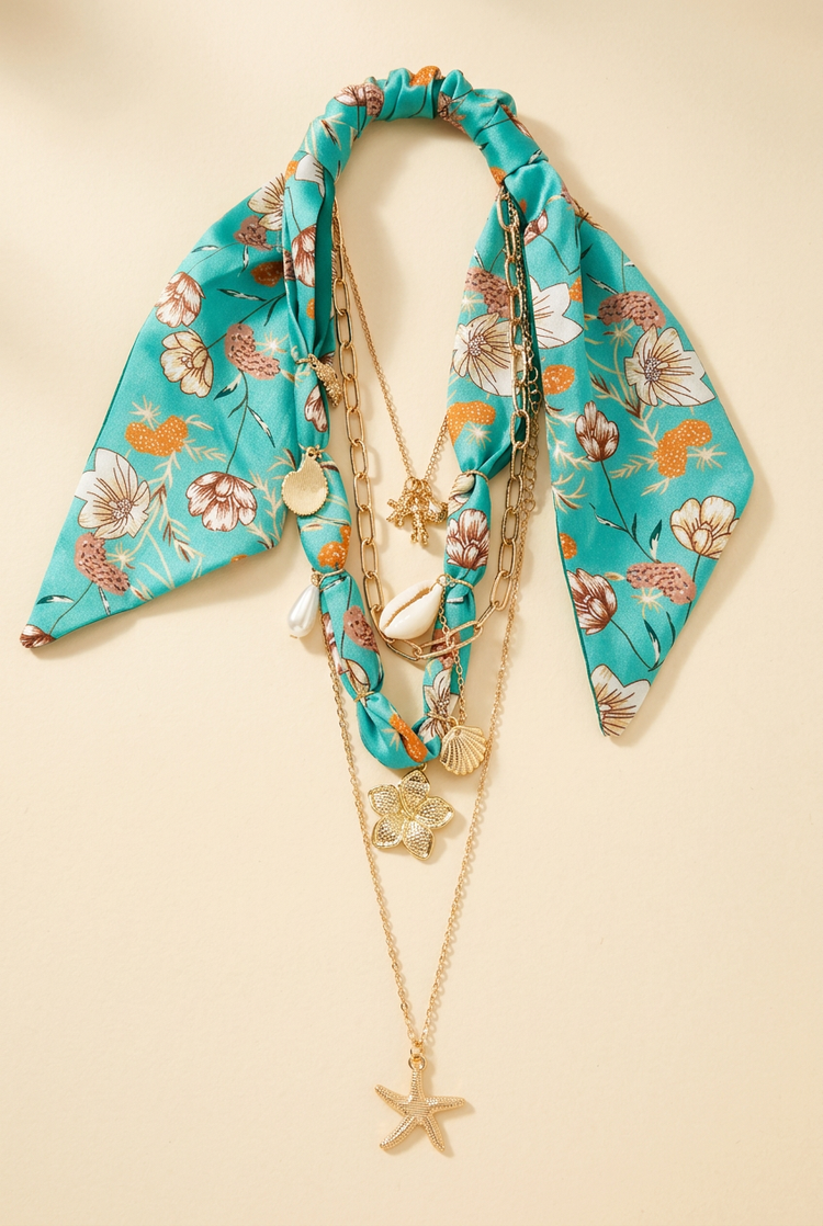 Turquoise floral scarf and layered gold starfish necklace on cream