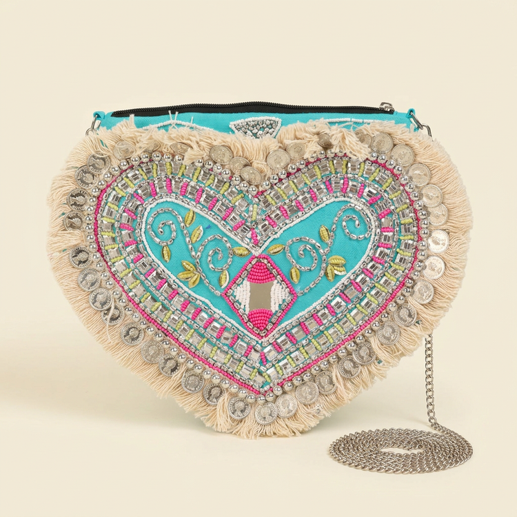 Dilara turquoise heart bag on a cream studio background