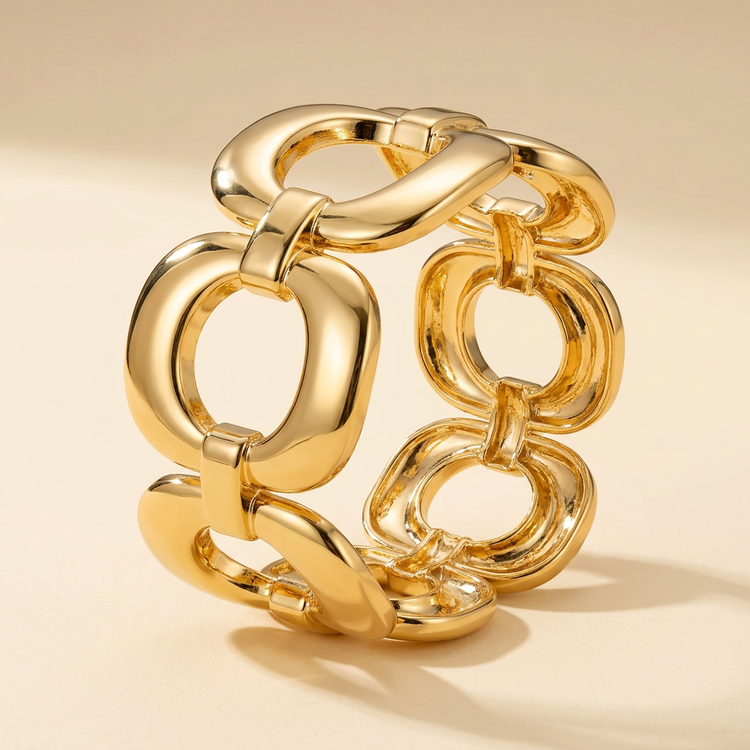 Sculpted oval-link gold bracelet on a cream studio background