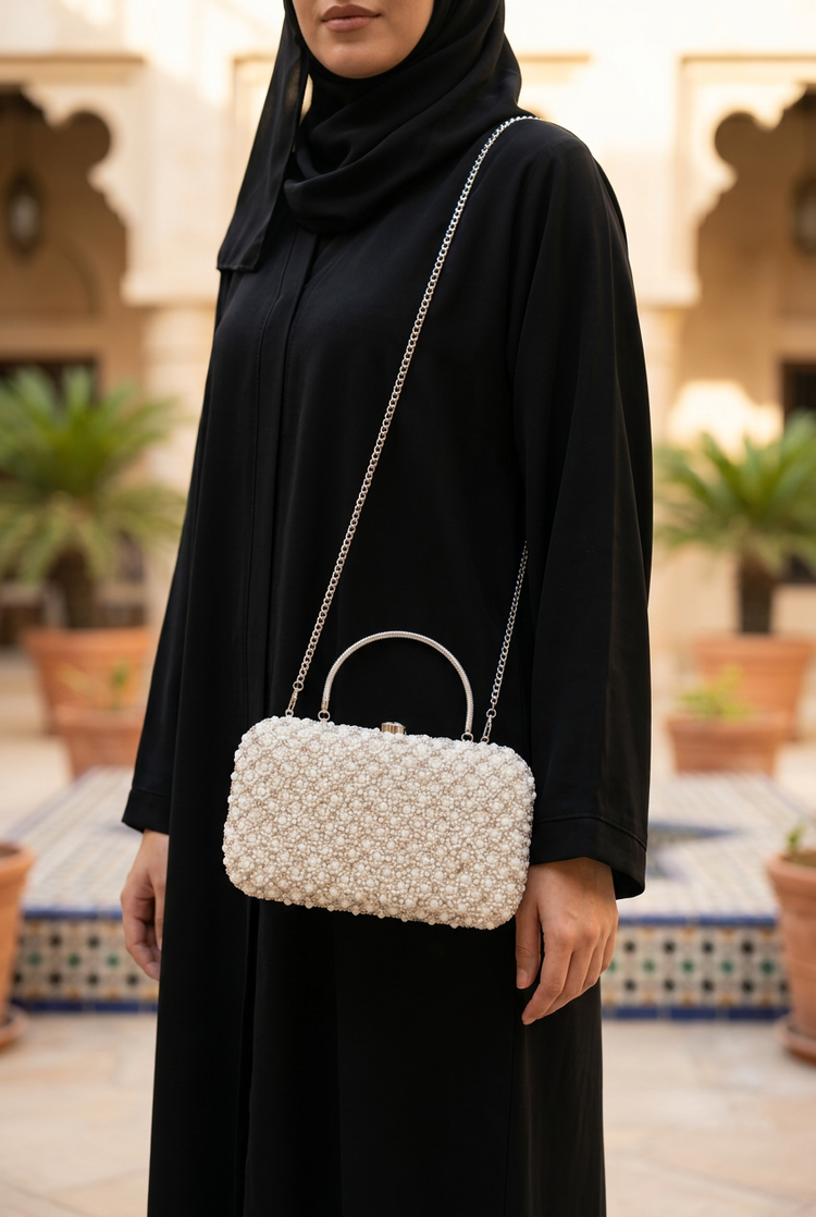 Pearl Radiance sling bag worn with black abaya
