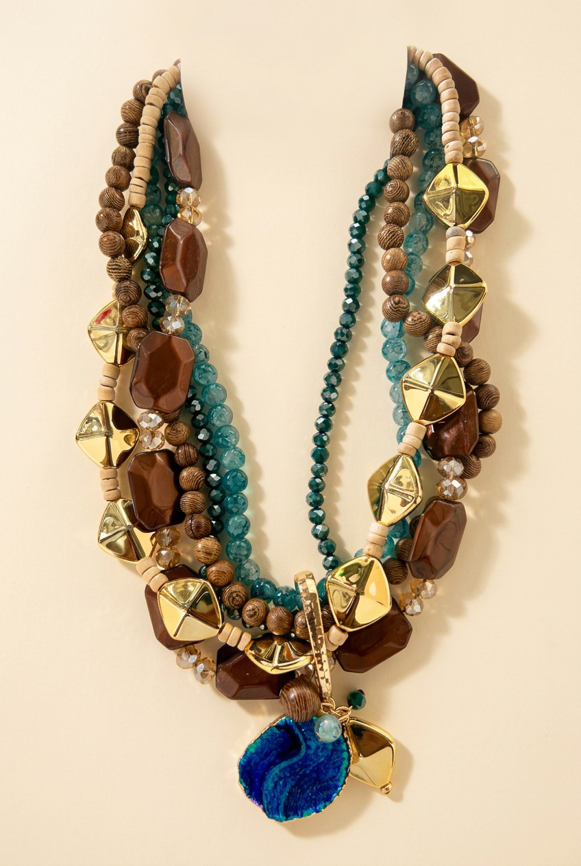 Teal brown and gold multistrand necklace with blue banded pendant on cream studio background