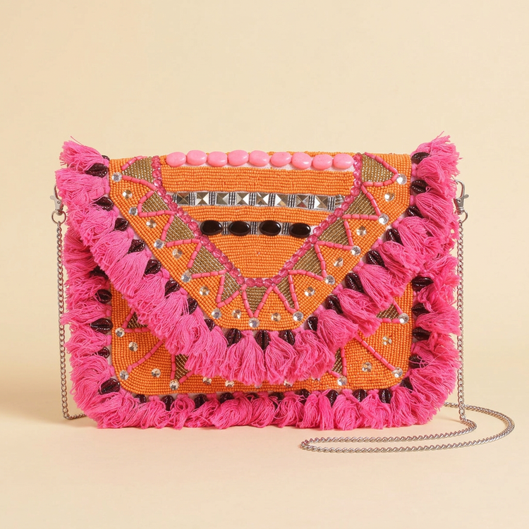 Mango Fiesta orange and pink tassel bag on cream studio background