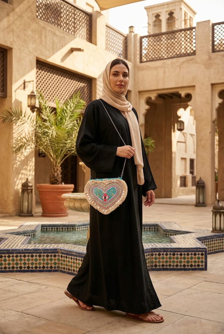 Dilara heart bag styled with a black abaya and sand shayla