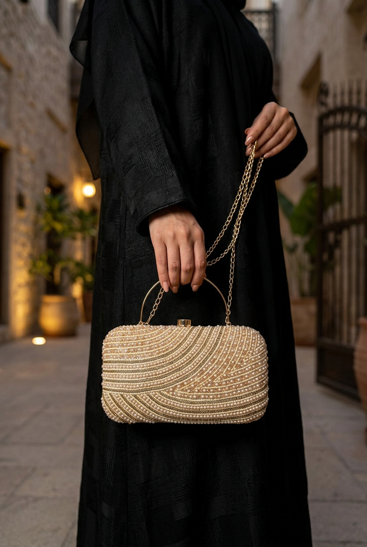 Satin Current Gold wave beaded clutch styled with an abaya