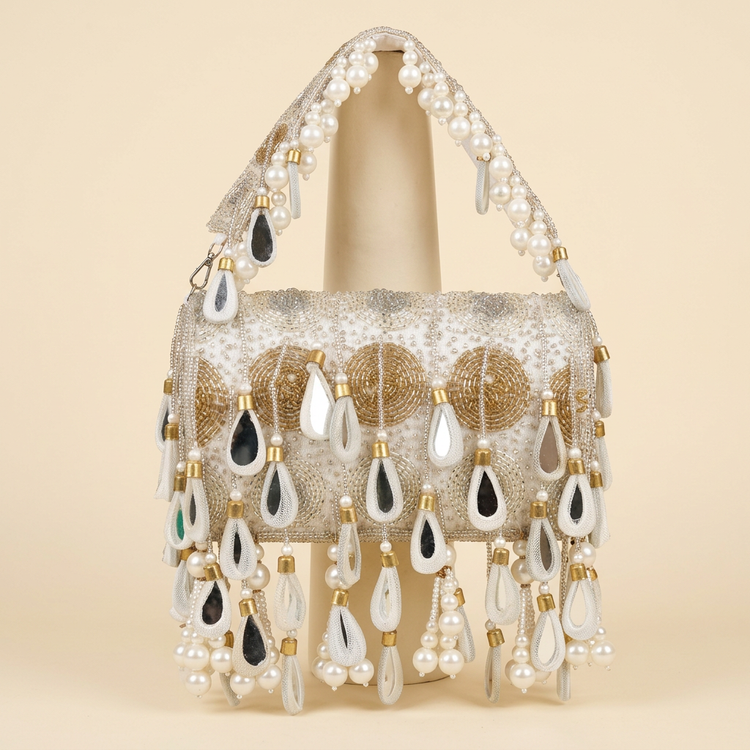 Ivory and gold teardrop pearl bag on a cream studio background