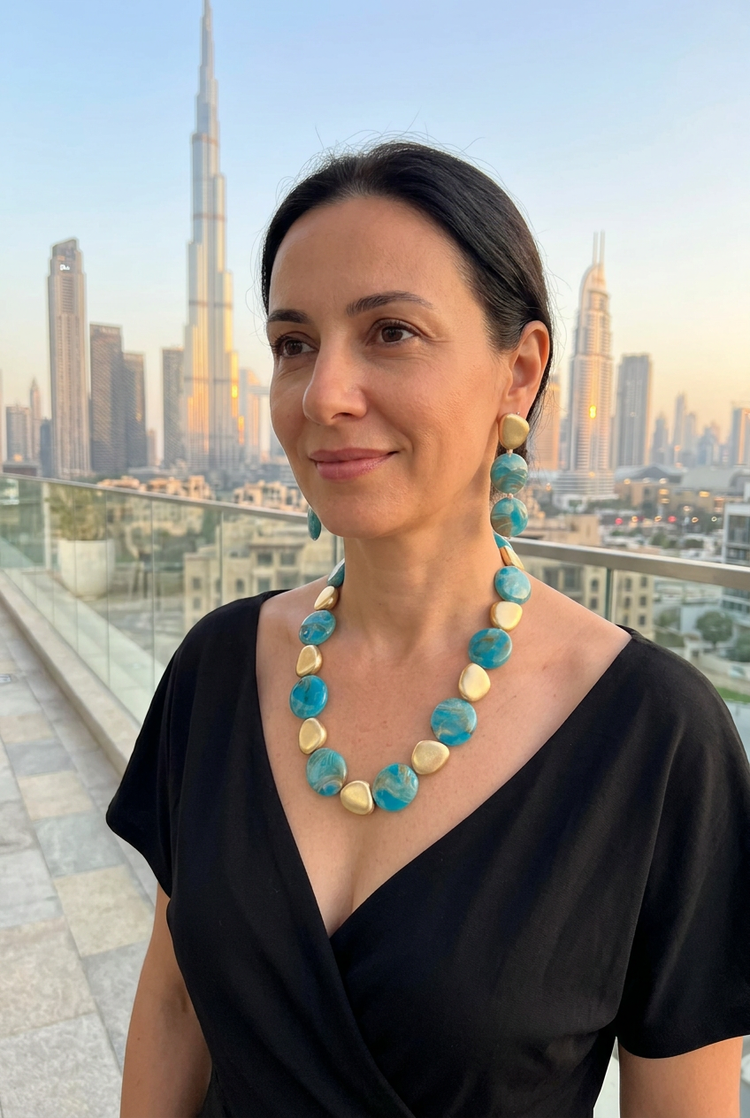 Medium-size blue marbled necklace and earrings set worn with black