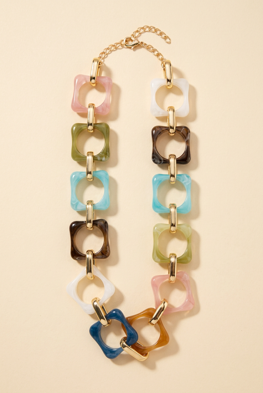 Multicolour marbled square-link necklace on a cream studio background