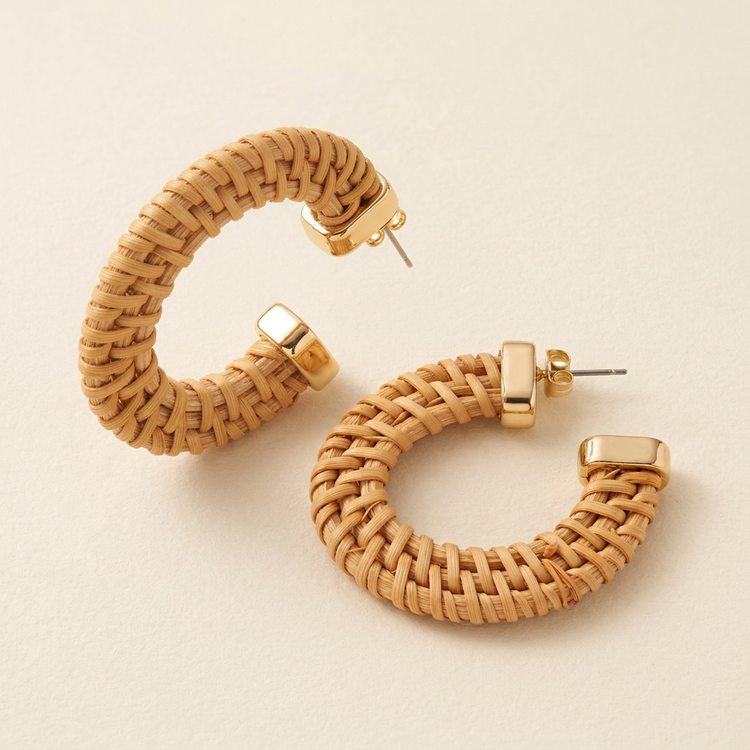 Angled view of natural woven hoop earrings and gold-tone end caps
