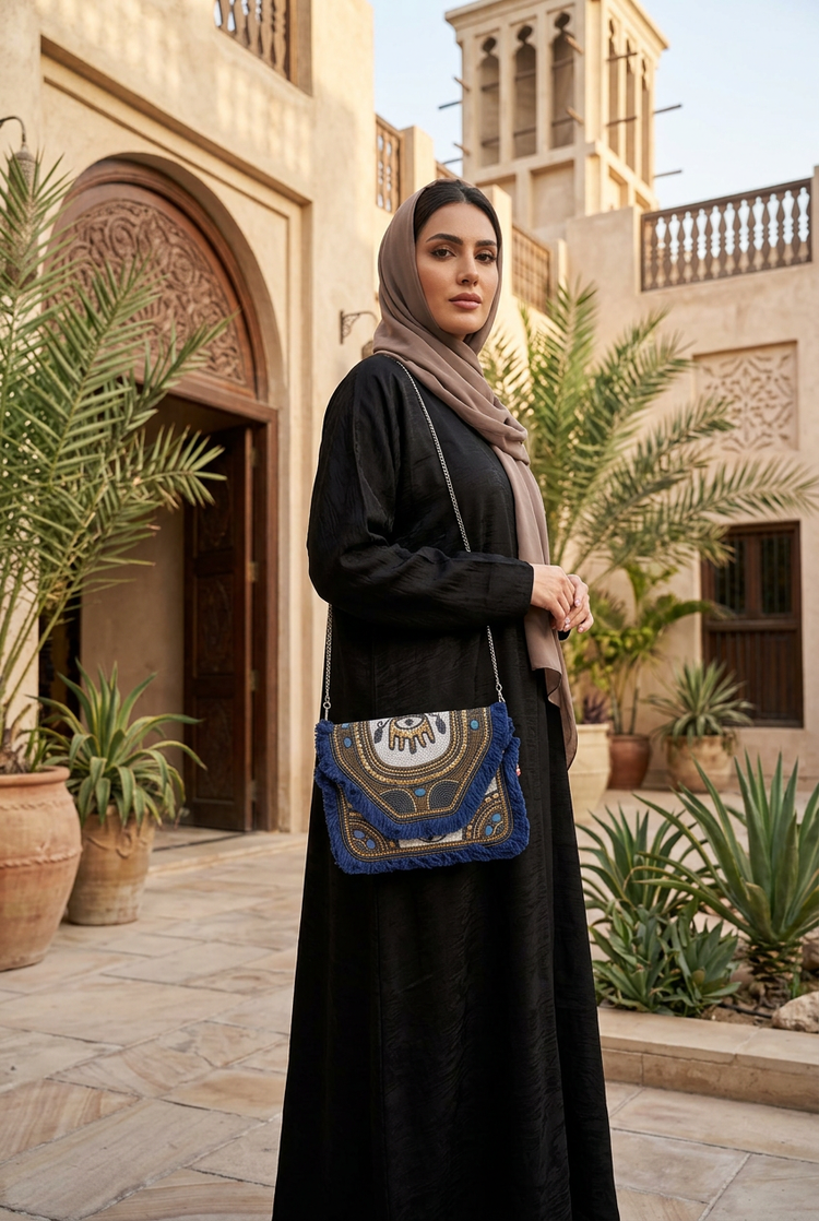 Blue Oracle compact navy bag styled with black abaya